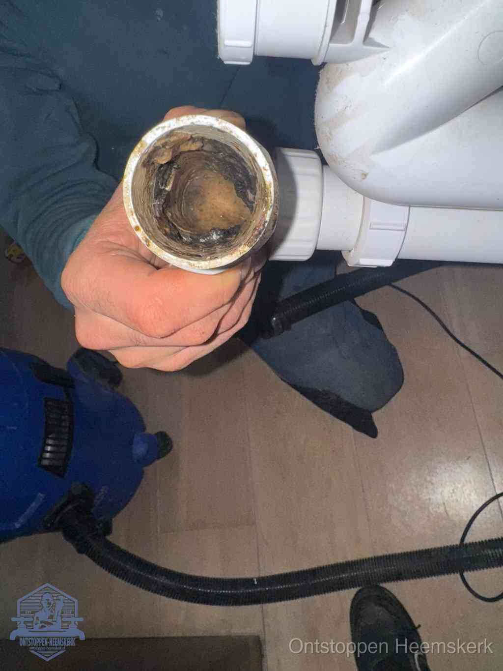 Een losgekoppeld afvoerbuisstuk dat van binnen volledig is dichtgeslibd, het gevolg van een verstopping te lang laten zitten in Heemskerk