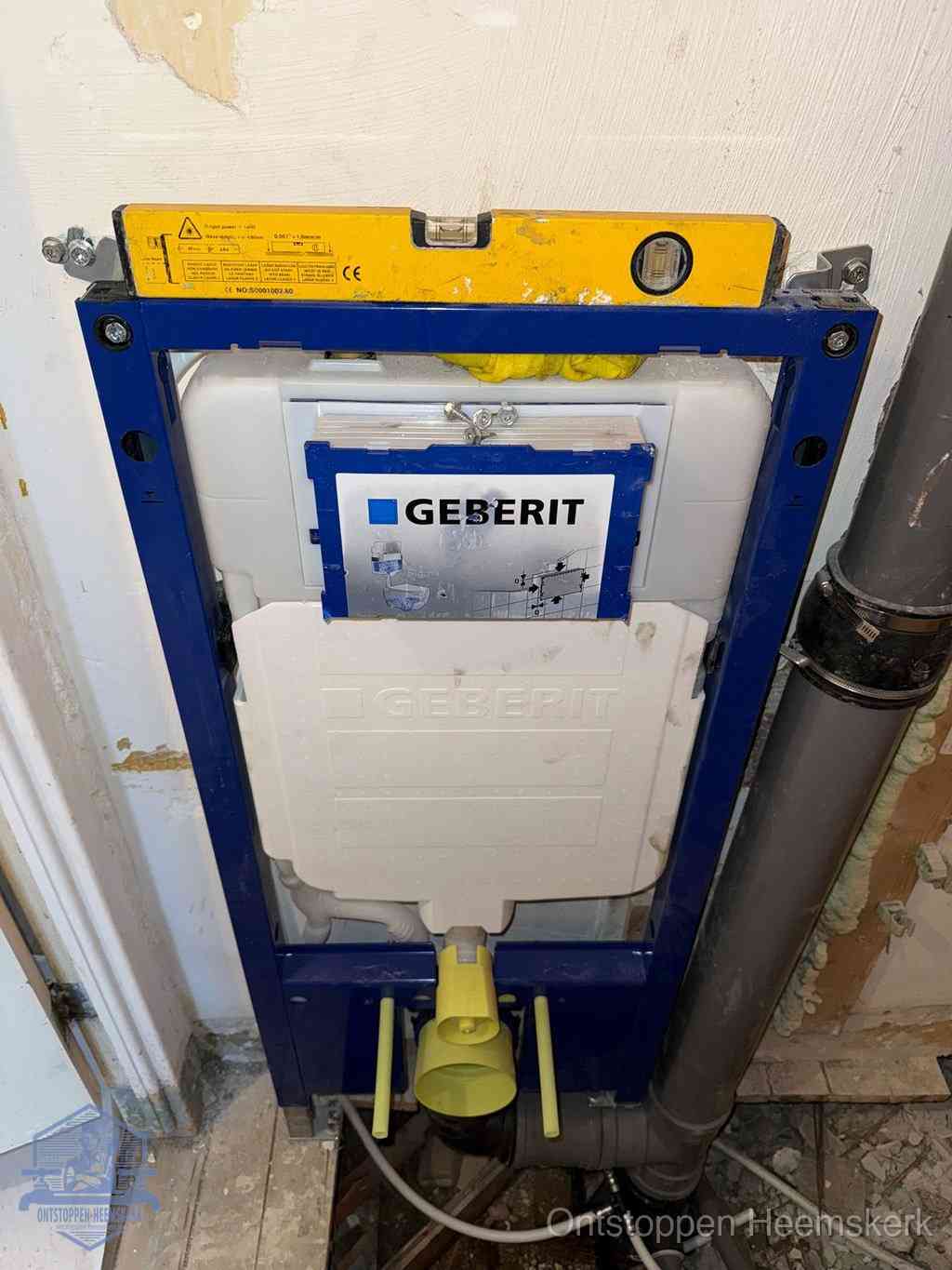 Een Geberit inbouwreservoir met frame voor een hangtoilet tegen de wand, met de afvoerbocht naar de vloer, kenmerkend voor een verstopt hangtoilet in Heemskerk