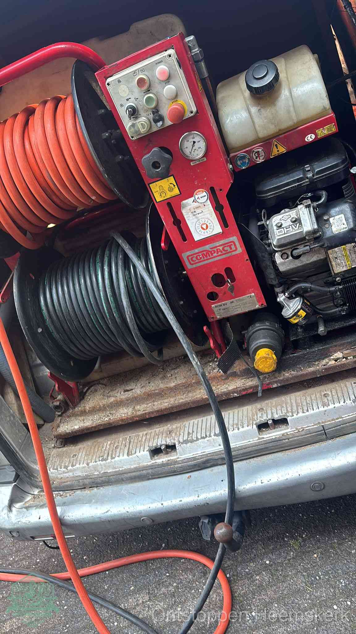 Een rood hogedruk-rioolreinigingstoestel in de laadbak van de bedrijfsbus, apparatuur voor een hardnekkige afvoerverstopping in Heemskerk