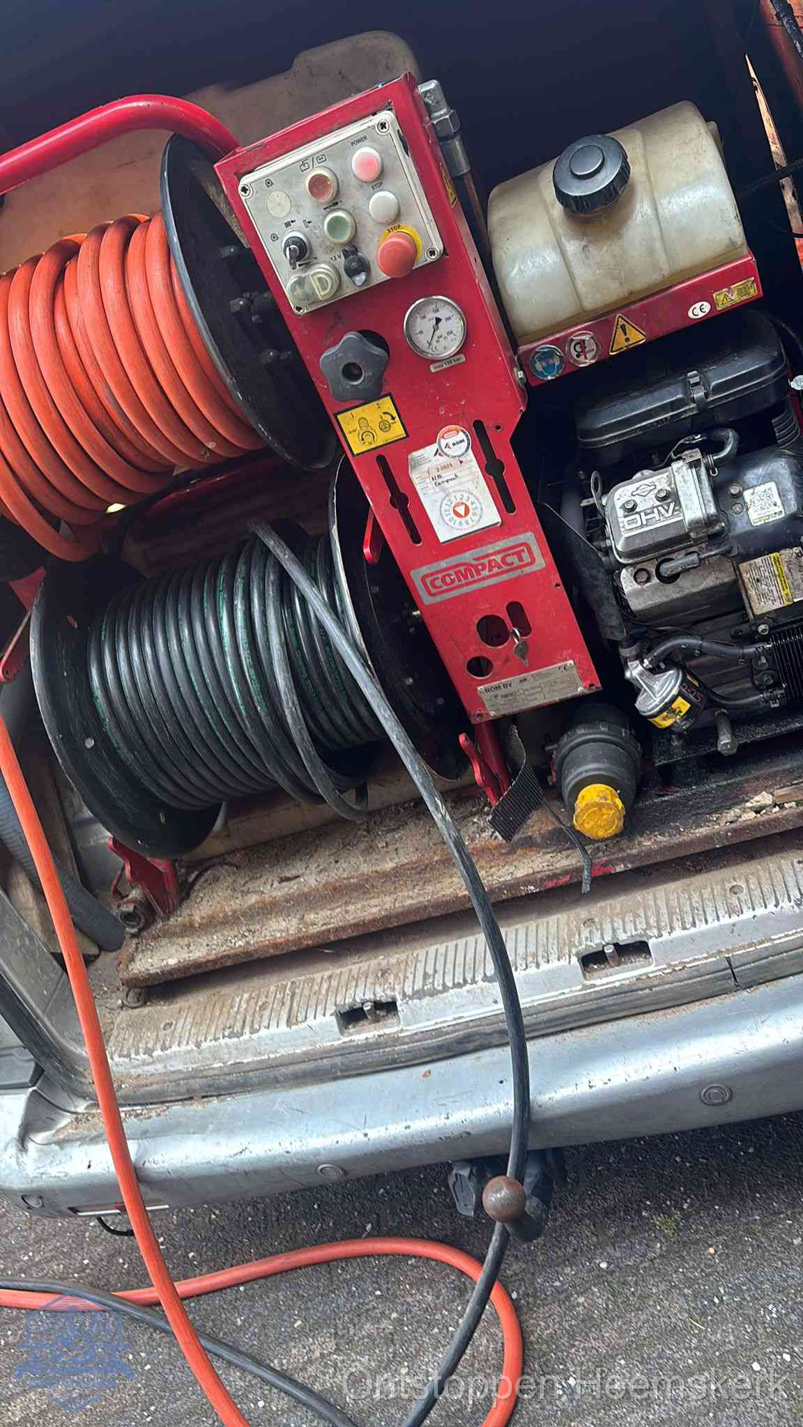 Een rood hogedruk-rioolreinigingstoestel met slangen in de laadbak van de bedrijfsbus, apparatuur voor een hardnekkige wc-verstopping in Heemskerk