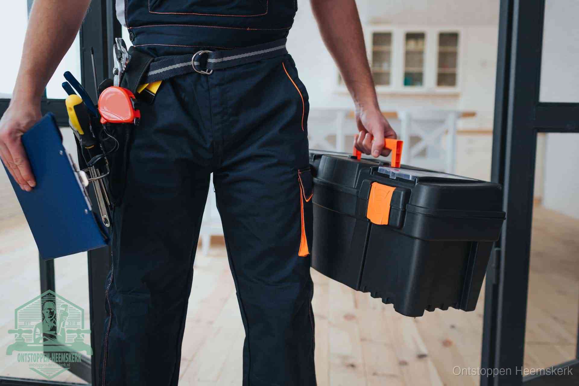 Een monteur met gereedschapsriem en klembord, klaar om een transparante prijs voor het afvoer ontstoppen in Heemskerk te geven