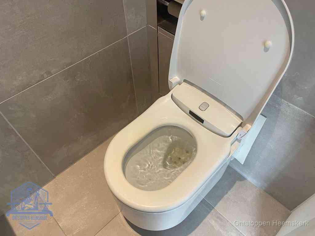 Een toiletpot vol troebel water met drijvend papier en restanten, de meest voorkomende oorzaak van een verstopte wc in Heemskerk