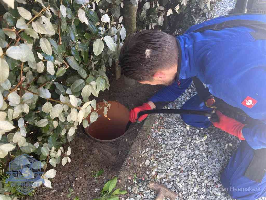 Monteur reinigt een rioolput met een slang, periodieke rioolreiniging in Heemskerk