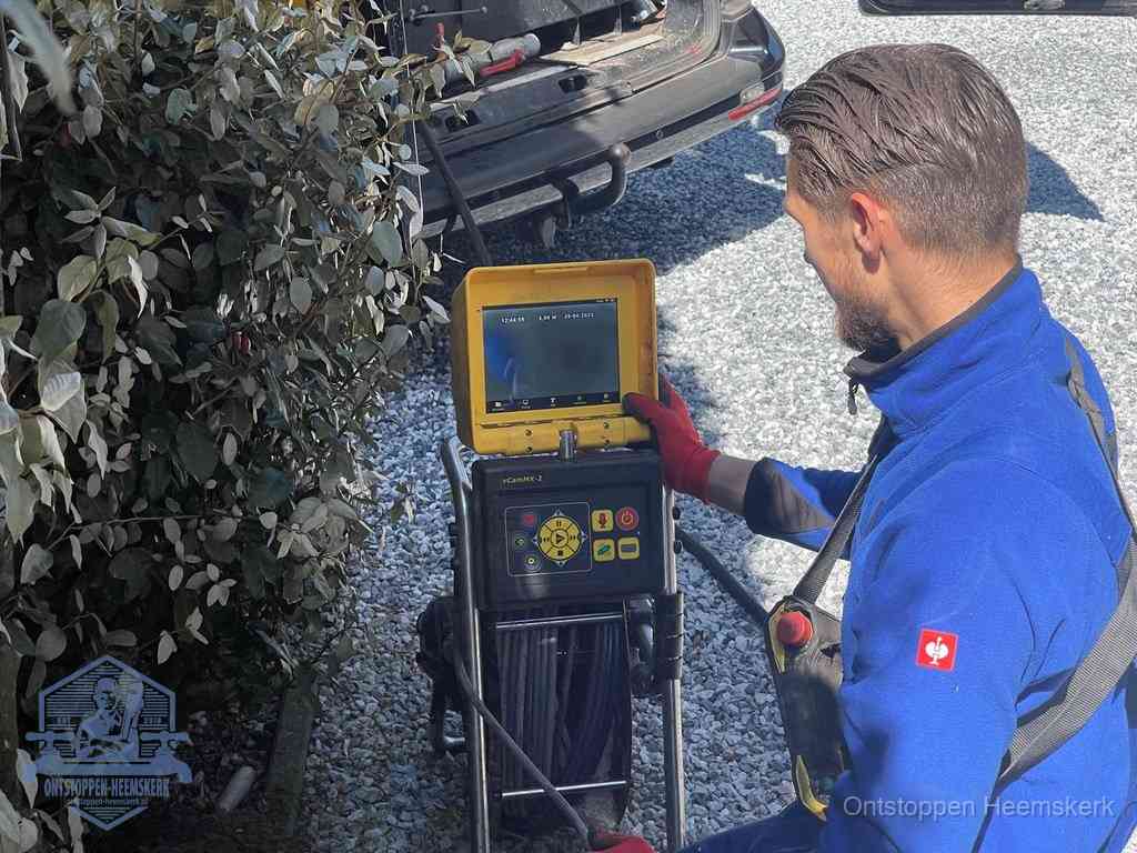 Monteur bedient een rioolinspectiecamera met monitor voor rioolinspectie in Heemskerk