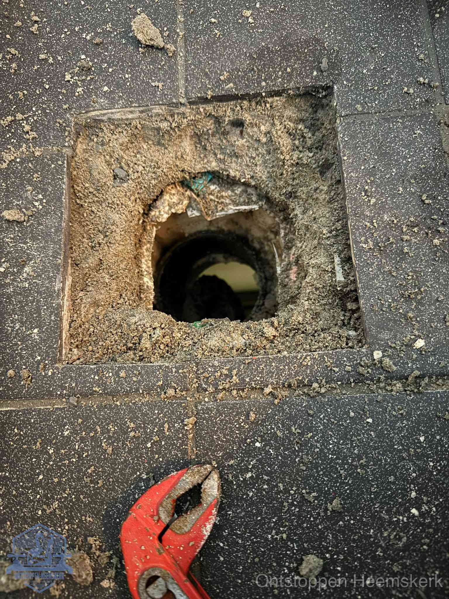 Geopend rioolputje op de erfgrens dat laat zien wie eigenaar is van de riolering in Heemskerk