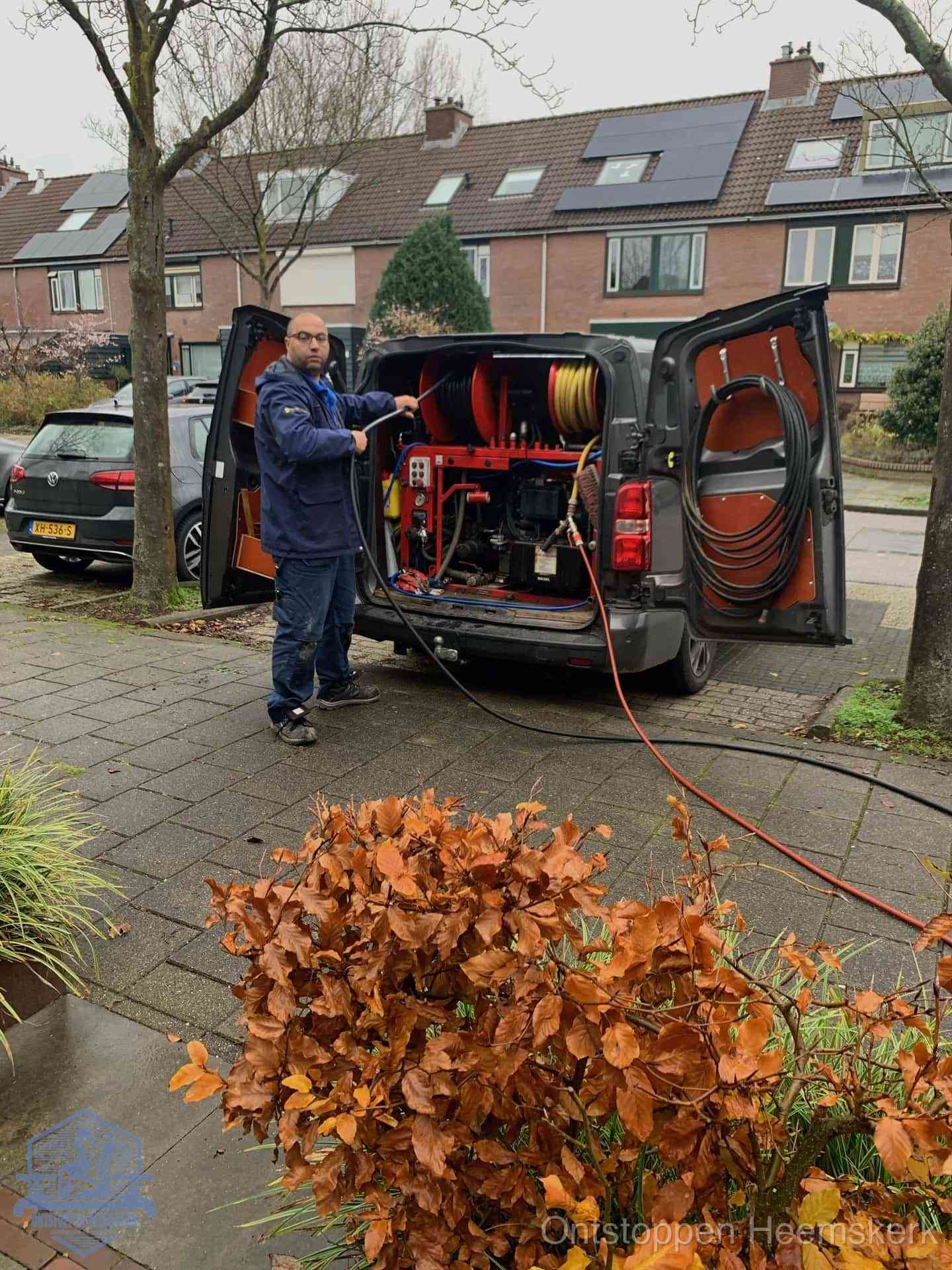 Monteur met rioolreinigingsbus levert rioolservice in de wijk in Heemskerk