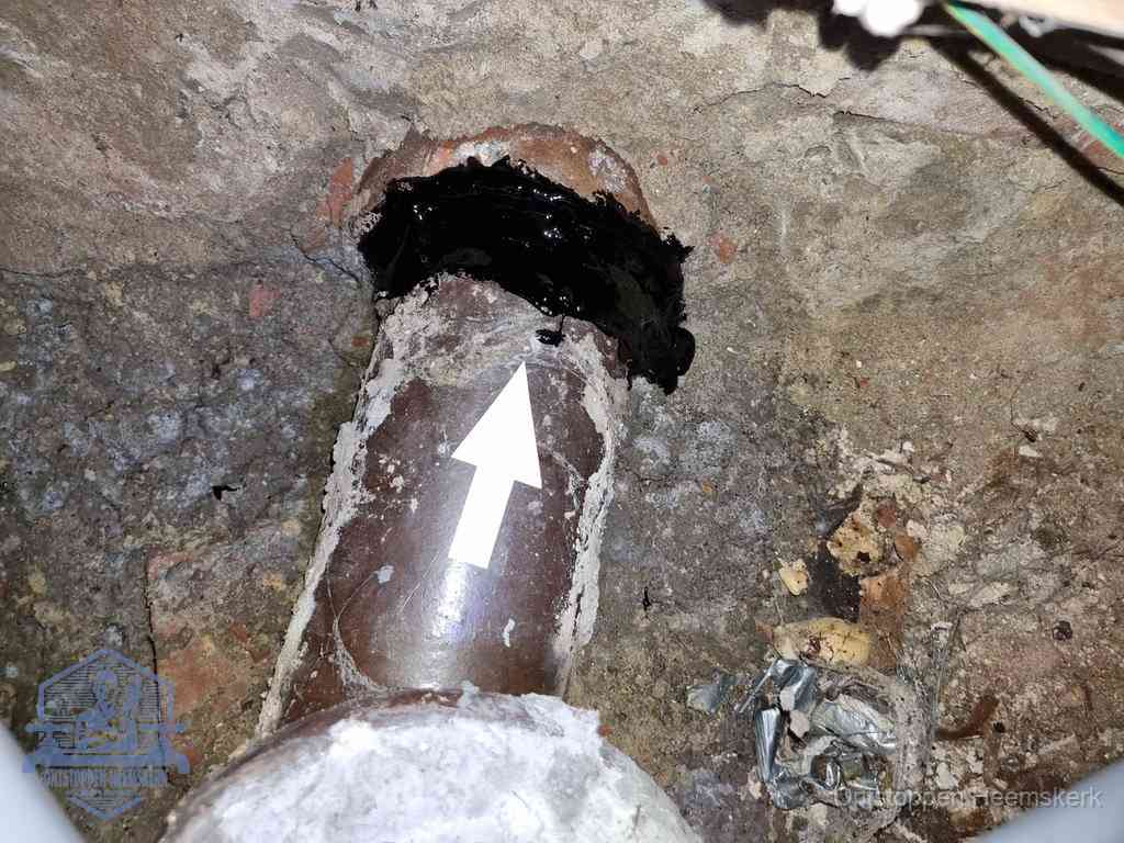 Een oude gres rioolbuis met een beschadigde koppeling onder de vloer, oorzaak van terugkerende structurele wc-problemen in Heemskerk