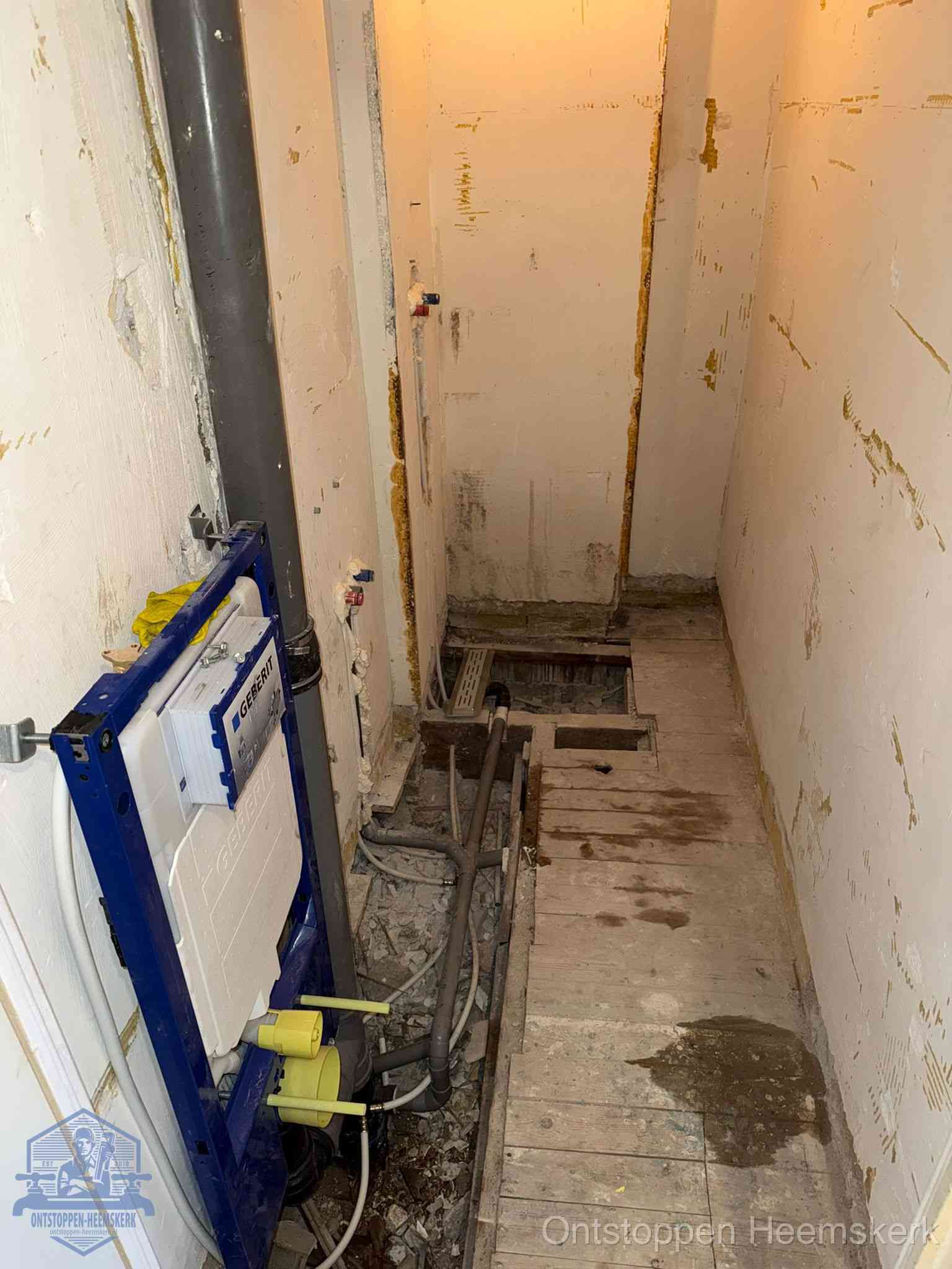 Een opgebroken toiletruimte tijdens renovatie met een Geberit inbouwreservoir en blootliggende oude afvoerleidingen, typisch voor oudere woningen in Heemskerk
